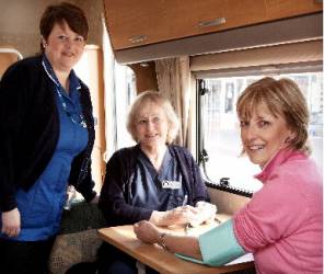 President Brian Franklin and Rotarian Keith Higgin ask for volunteers, whilst the nurses carry out checks on two ladies in front of the Rotary exhibition stand.